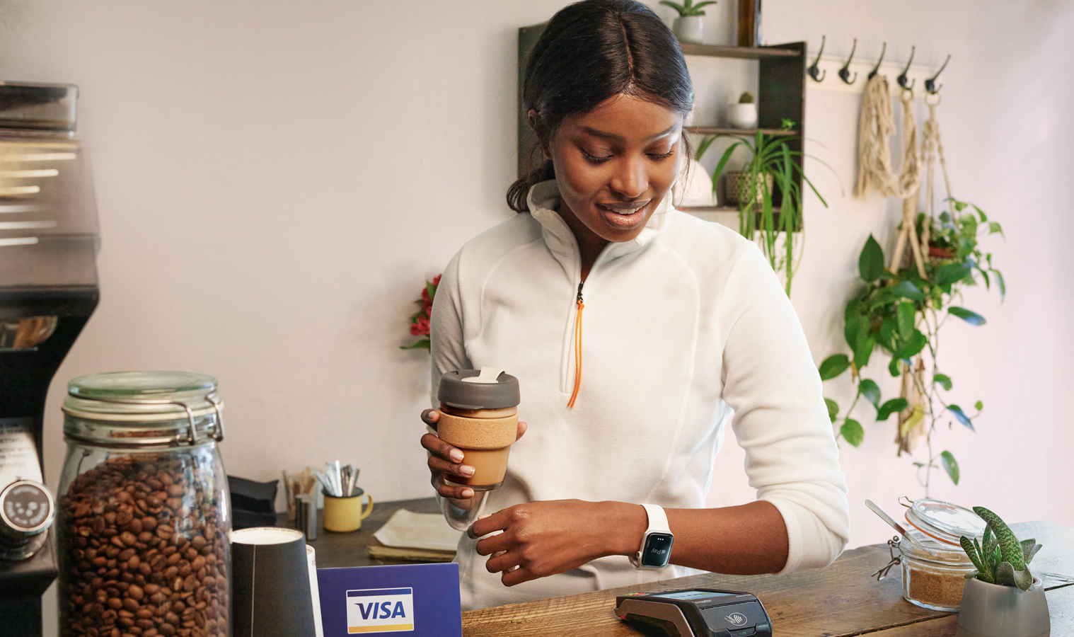 A lady using her apple watch to make a contactless payment in a coffee shop