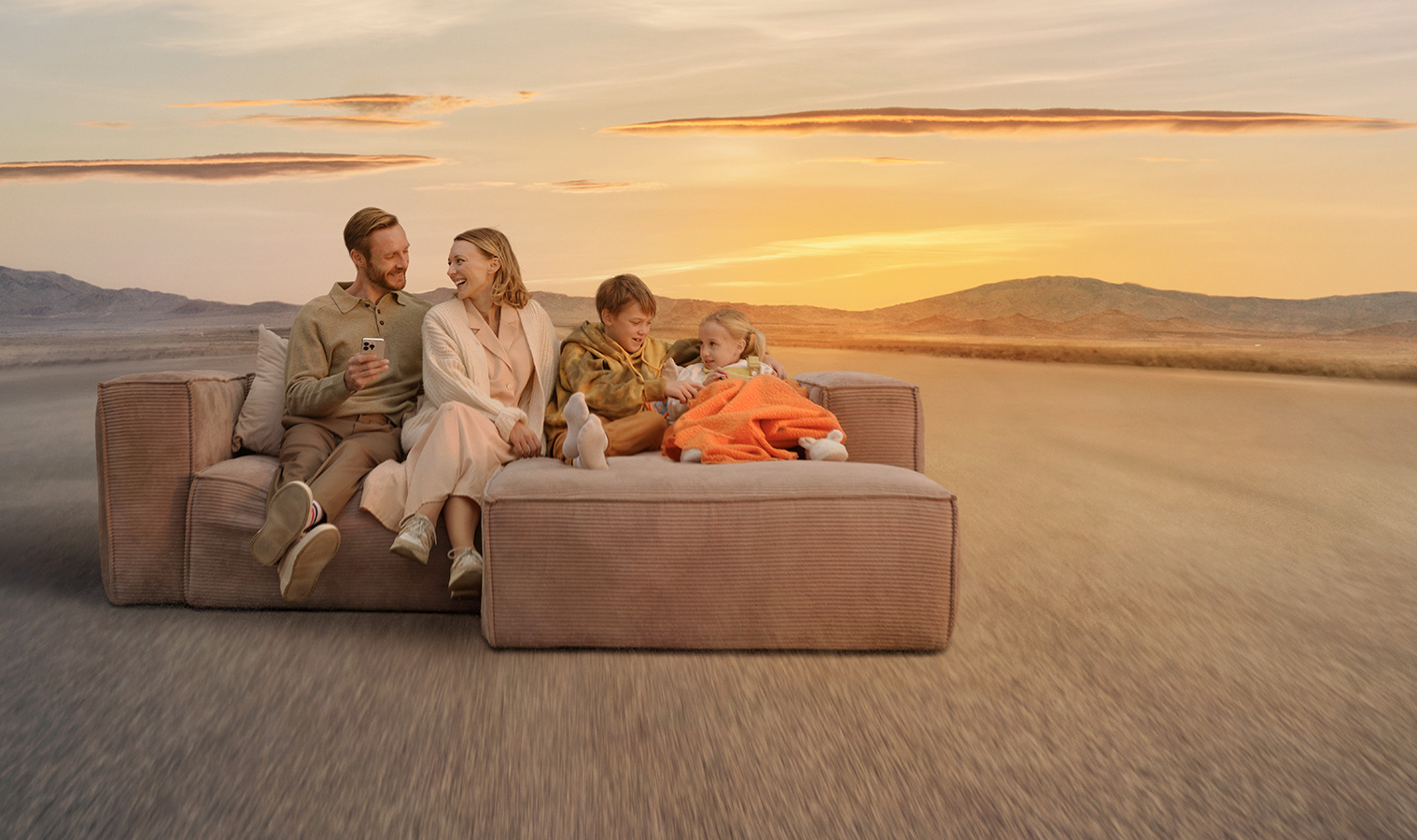 A family of four sitting on a sofa in the desert