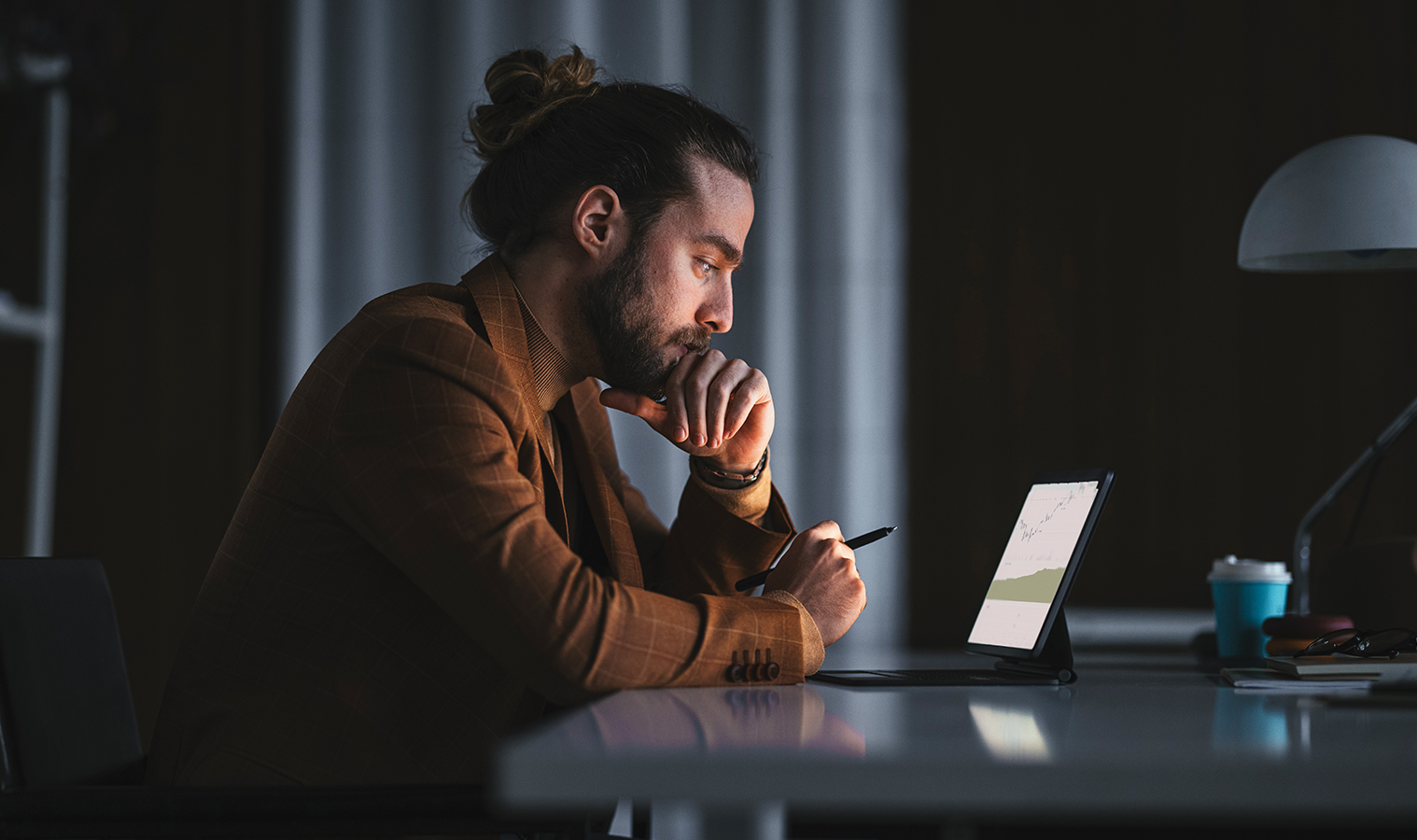 Man on a tablet in a dark kitchen